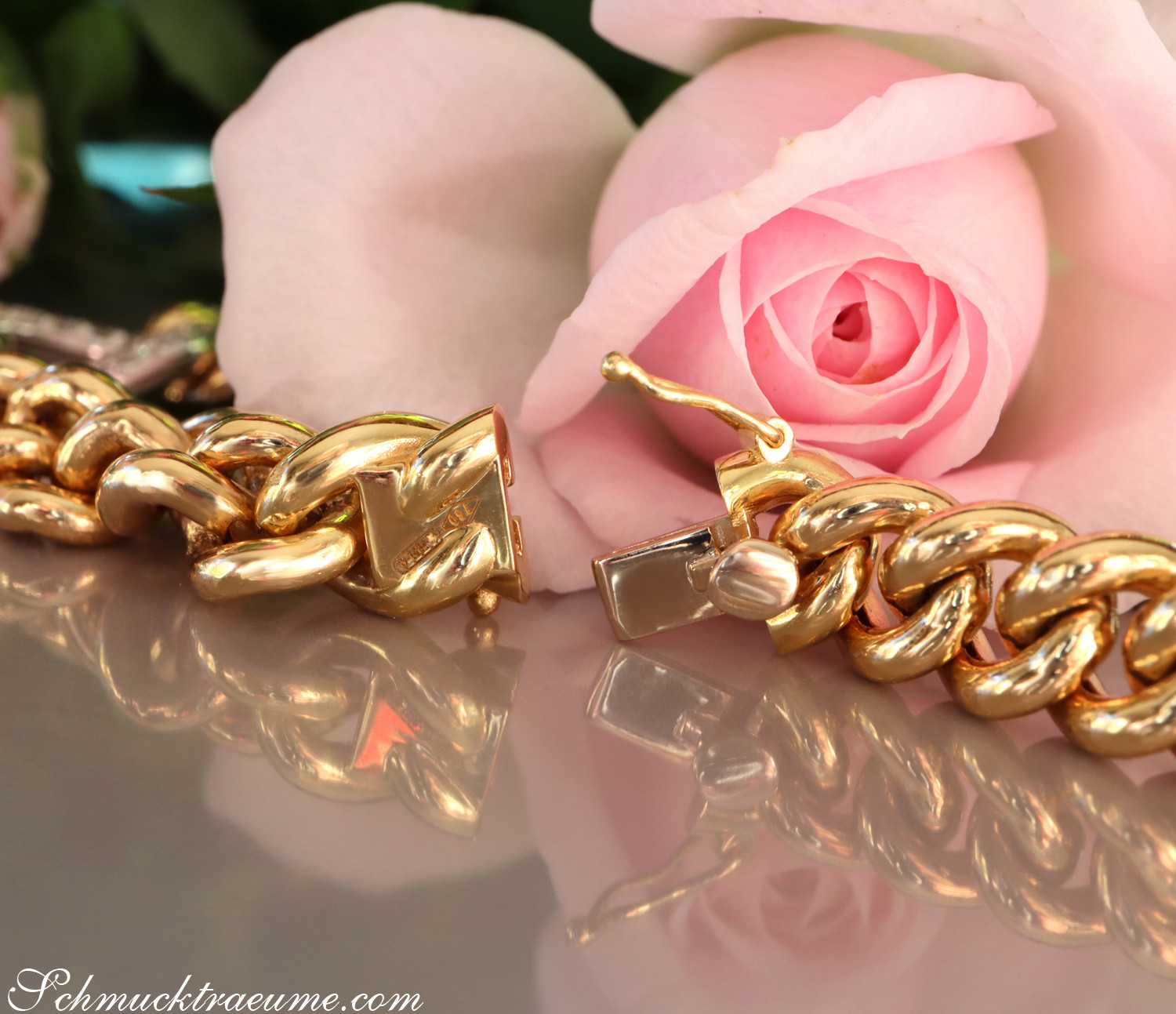 Goldene Panzerarmband-Detail mit Rosenblüte im Hintergrund