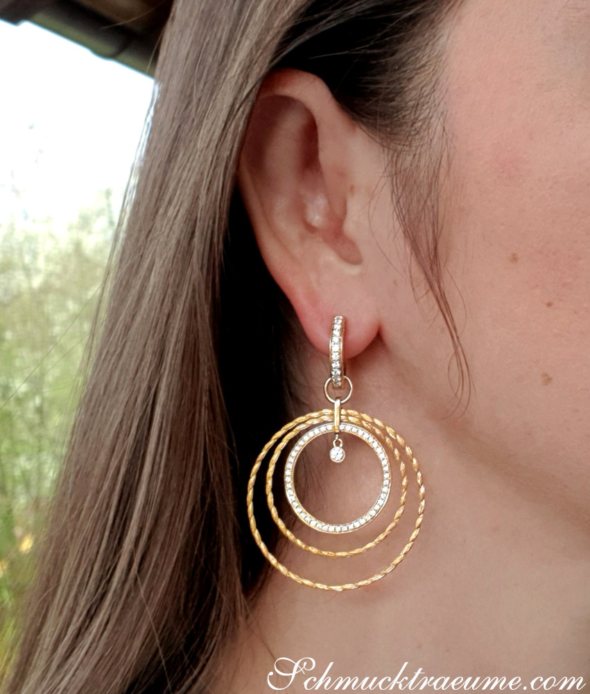 Goldene Kreisohrringe mit Brillanten in Bewegung, elegant getragen.
