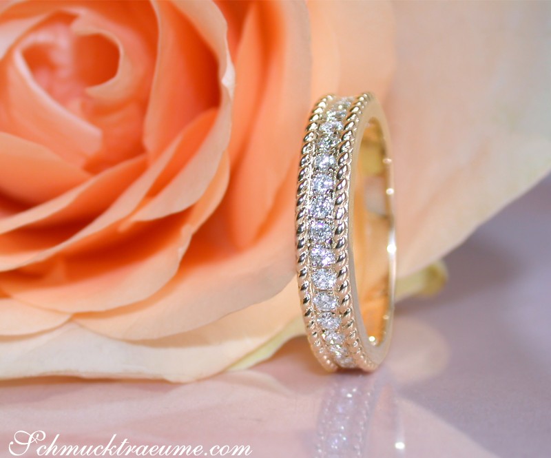 Kordel-Diamantring in Gelbgold 585, detailreich, elegant, mit Rosenblüte im Hintergrund