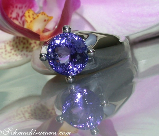 Klassischer Tansanit Solitär-Ring in Weißgold 750, präsentiert auf Orchideenblüte Klassischer Tansanit Solitär-Ring in Weißgold 750, präsentiert auf Orchideenblüte