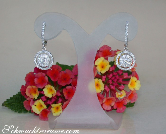 Detail der Diamantohrringe in Weißgold 750 vor Blumenarrangement