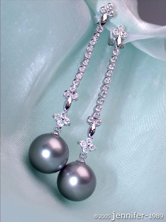 Tahitiperlen-Ohrringe mit Diamanten, Detailaufnahme, elegant, Perlen, Strass, Silber, Hintergrund aus Satin.