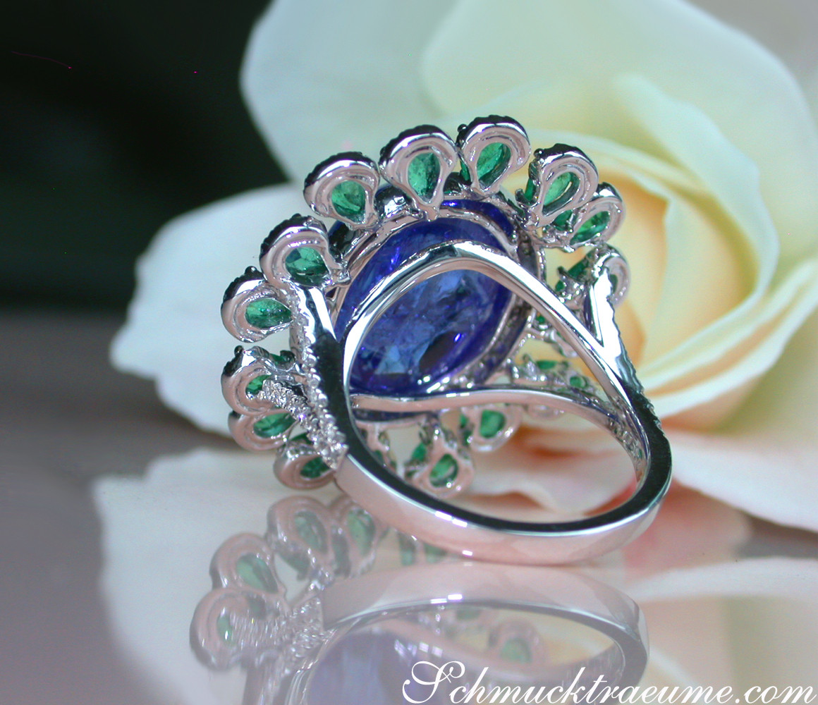 Opulenter Tansanit-Ring mit Smaragden und Brillanten, detailreich, auf Rosenblüte liegend