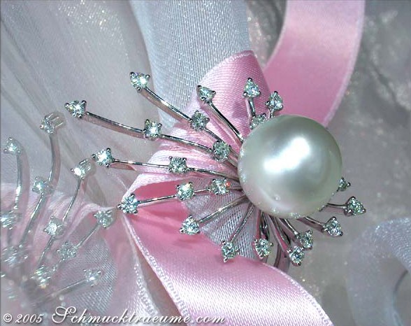 Detailaufnahme eines Südseeperlen-Rings mit strahlenden Brillanten auf Satinband