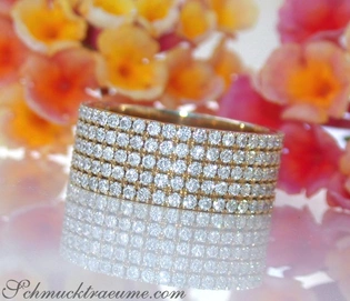 Flacher Diamantenring in Gelbgold 750, voller Brillanten, vor Blumenhintergrund