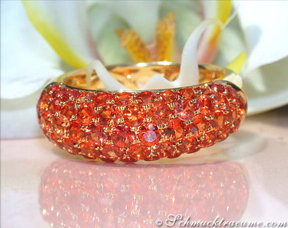 Goldener Pavé-Ring mit orangenen Saphiren auf glänzender Unterlage