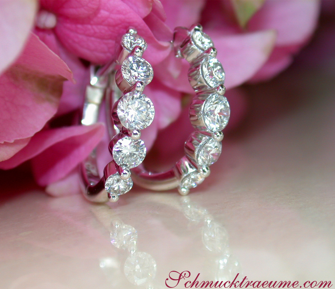Feine Brillantenohrringe aus Weißgold, zehn steigende Diamanten, rosafarbener Hintergrund