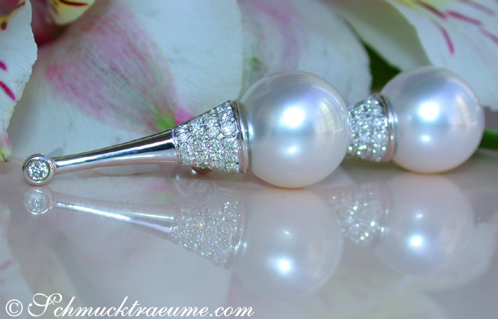 Detail der Südseeperlen-Ohrstecker mit Brillanten, elegant verziert, auf Blütenblättern liegend