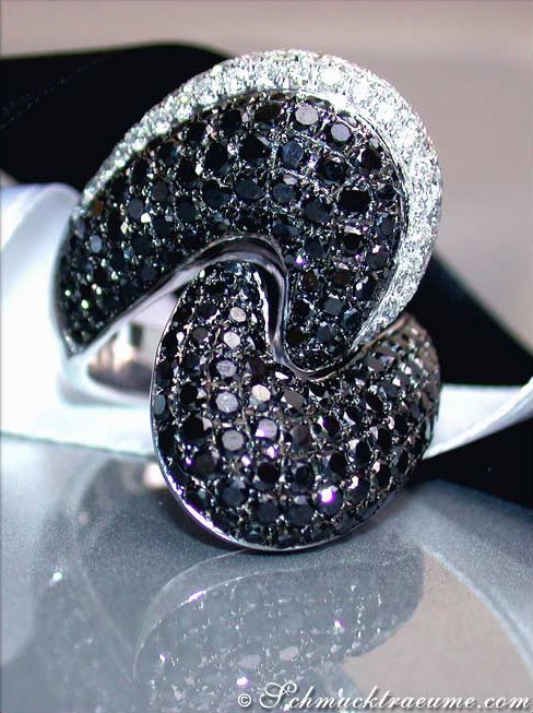 Schwarz-weißer Diamant-Ring mit gewelltem Design, detailreich, auf schwarzem Samt liegend