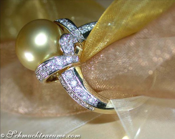 Goldener Südseeperlen-Ring mit Brillanten, elegantes Design auf gelbem Organza-Hintergrund