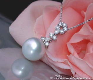 Detailaufnahme eines Südseeperlenanhängers mit Brillanten & Diamanten, präsentiert auf einer rosa Rose