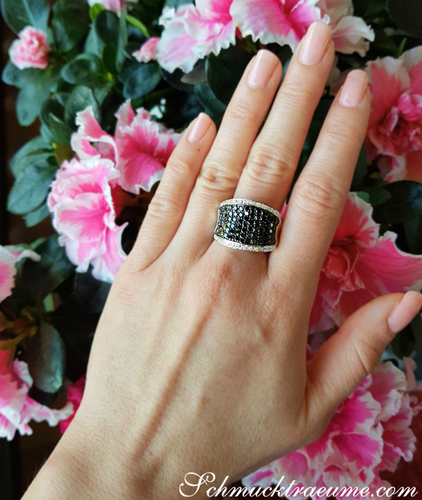 Schwarzer Diamant-Ring auf blühendem Hintergrund, Detailansicht, elegant.