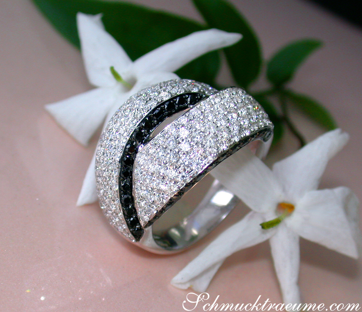 Klassischer Brillant-Ring mit schwarzen Diamanten, Detailansicht, weißer Blume im Hintergrund