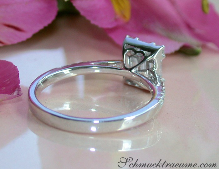 Weißgold 750 Ring mit Brillant Carré und Baguette Diamanten, Detailaufnahme, elegant, rosa Blüten im Hintergrund