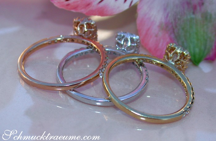 Goldene und silberne Stacking-Ringe mit Baguette-Diamanten, rosé-goldene Blume im Hintergrund