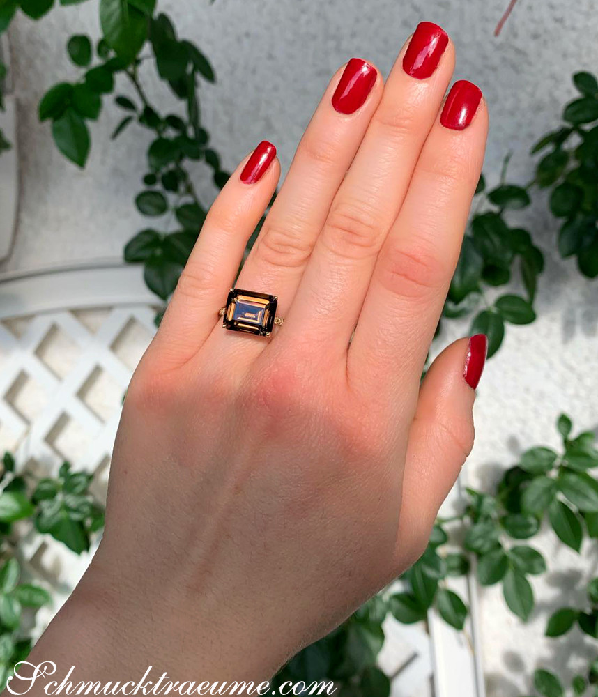 Raubraunfarbener Rauchquarz-Ring mit braunen Diamanten auf Hand mit roten Nagellack