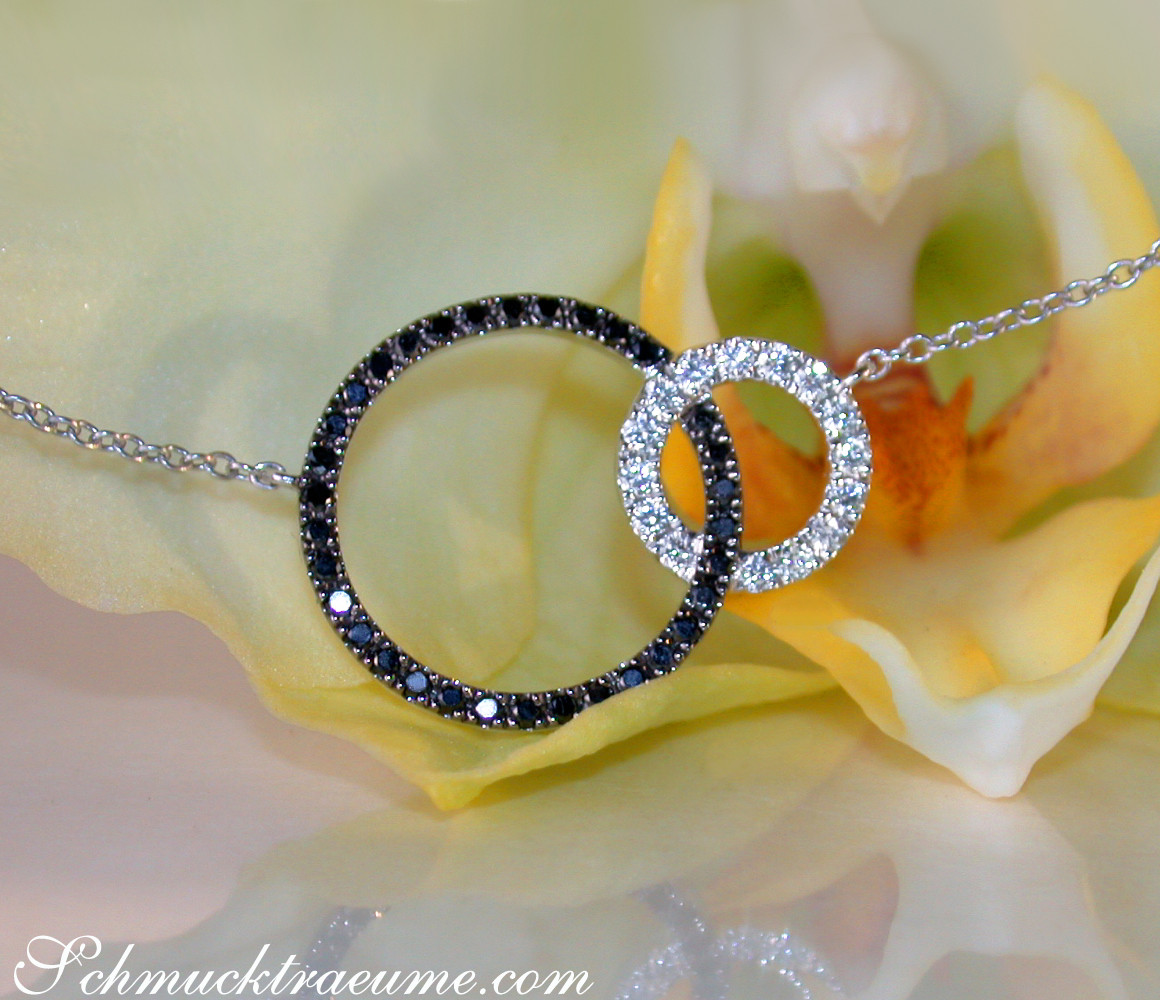 Silberkette mit schwarzen & weißen Diamantkreisen auf Blume liegend