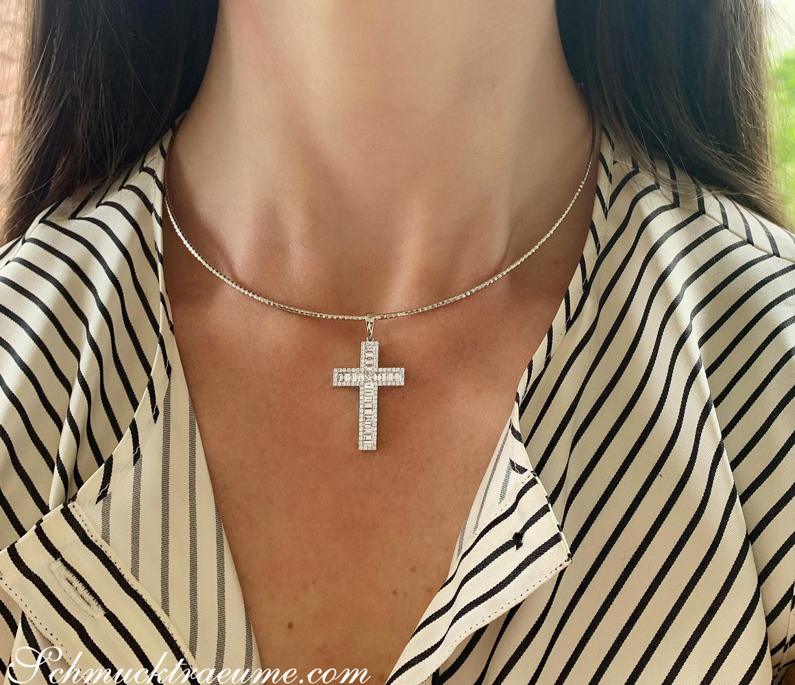 Kreuzanhänger mit Baguette Diamanten, Detailaufnahme, zarte Kette, Strickjacke mit Streifen.