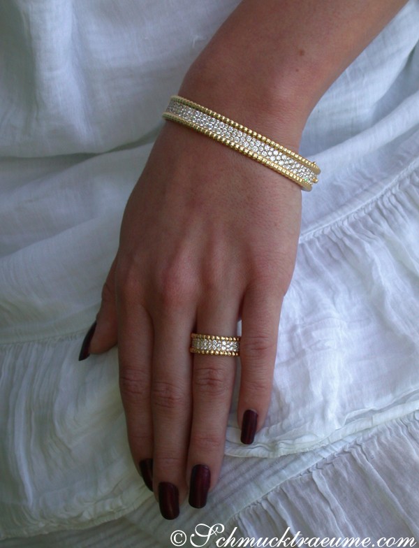 Goldene Armbänder mit Diamanten auf weißem Hintergrund