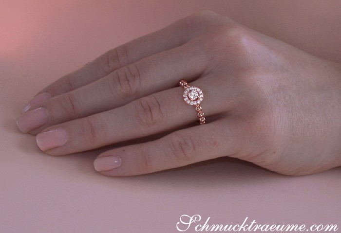 Finger mit elegantem Brillanten-Ring in Roségold, detailreiches Design, zarte Handhaltung.