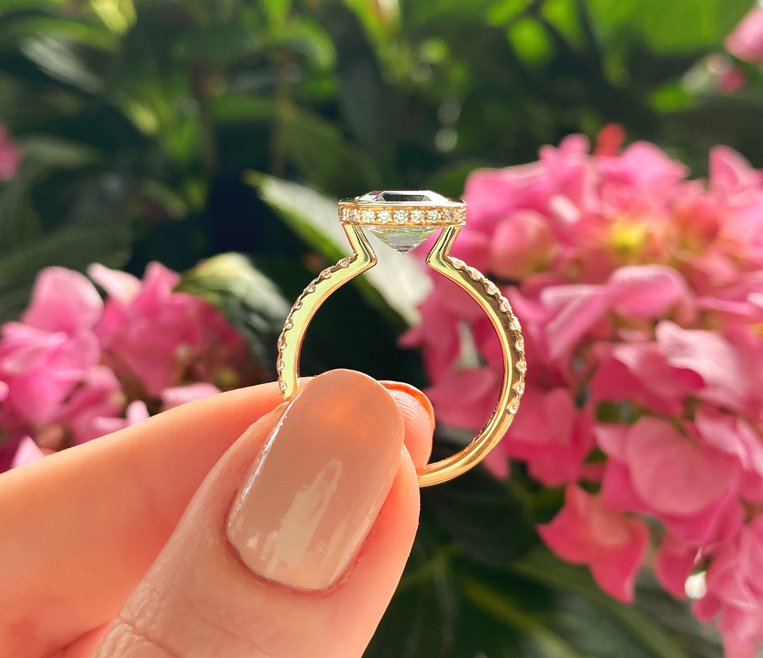 Aquamarin-Ring 585 Gelbgold, Detailaufnahme mit Blumen im Hintergrund