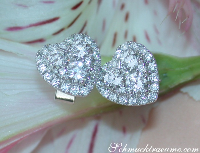 Herzformige Ohrstecker aus Weißgold 750 mit Brillanten auf Blüte.