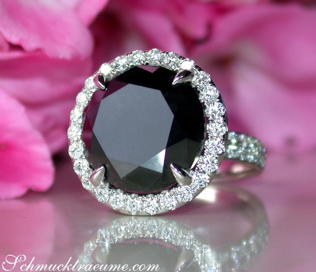 Schwarzer Diamant Solitär-Ring mit Brillanten, Weißgold 750, rosa Hintergrund, Detailaufnahme Schwarzer Diamant Solitär-Ring mit Brillanten, Weißgold 750, rosa Hintergrund, Detailaufnahme