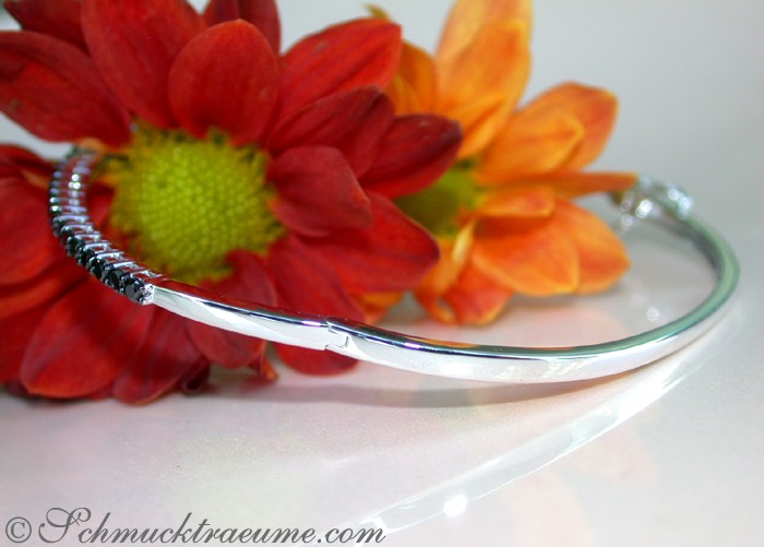 Armreif aus Weißgold 585 mit schwarzen Diamanten, blühende Blume im Hintergrund