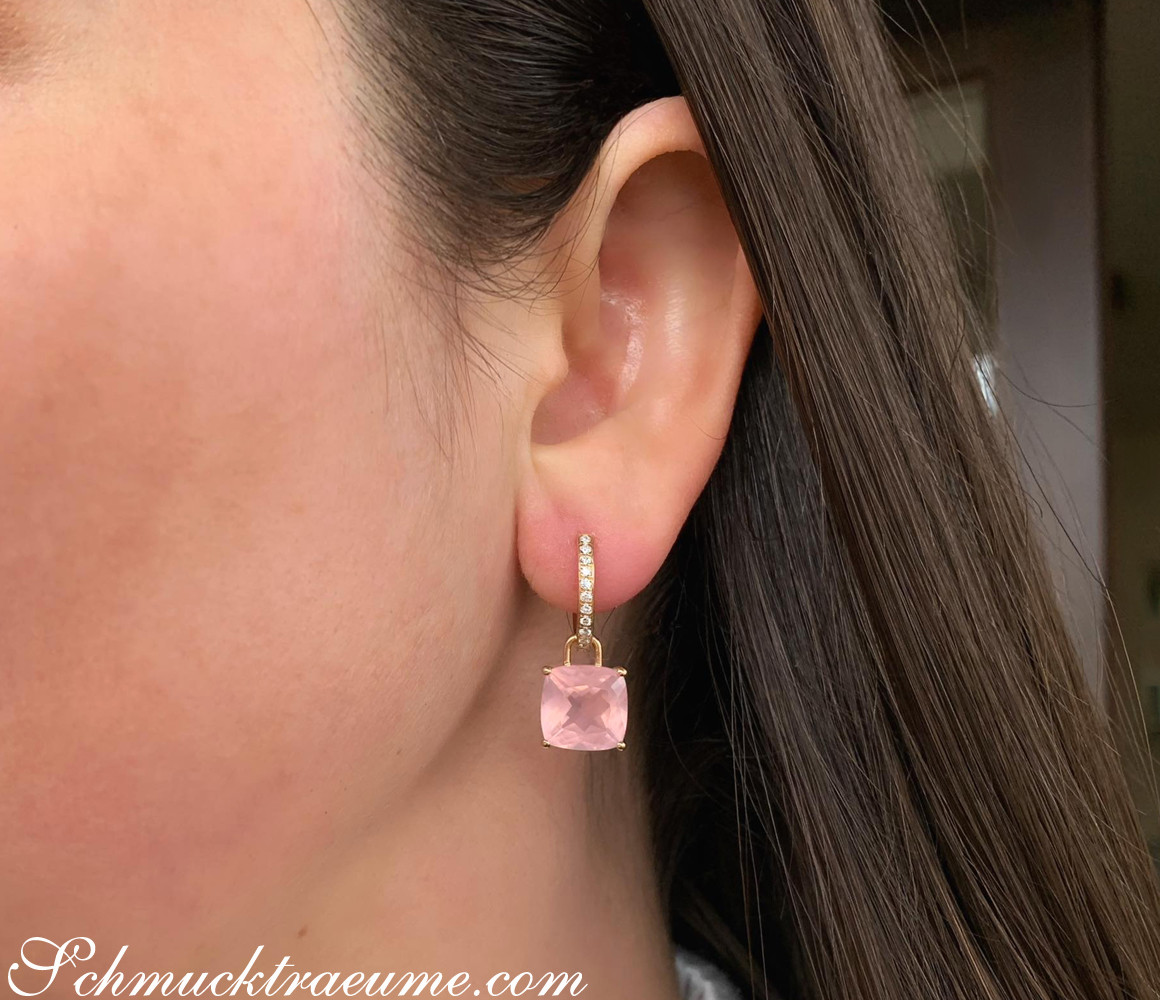 Goldener Ohrring mit rosa Quarz und Diamanten, Detailaufnahme an Ohr getragen.