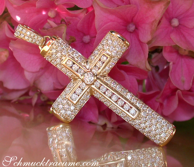 Goldener Kreuzanhänger mit Diamanten auf Blumenhintergrund Goldener Kreuzanhänger mit Diamanten auf Blumenhintergrund